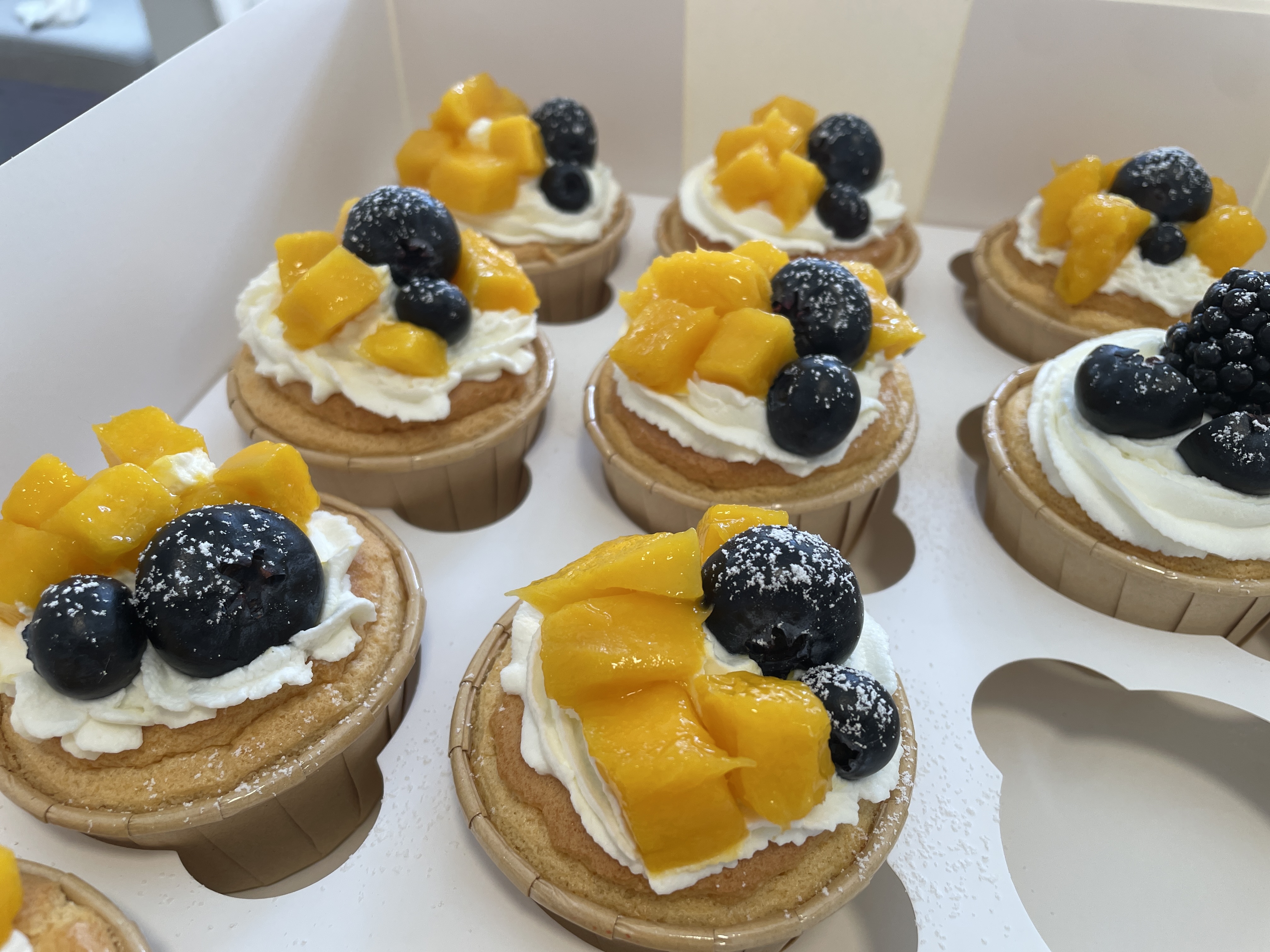 Box of mango and blueberry fruit cupcakes