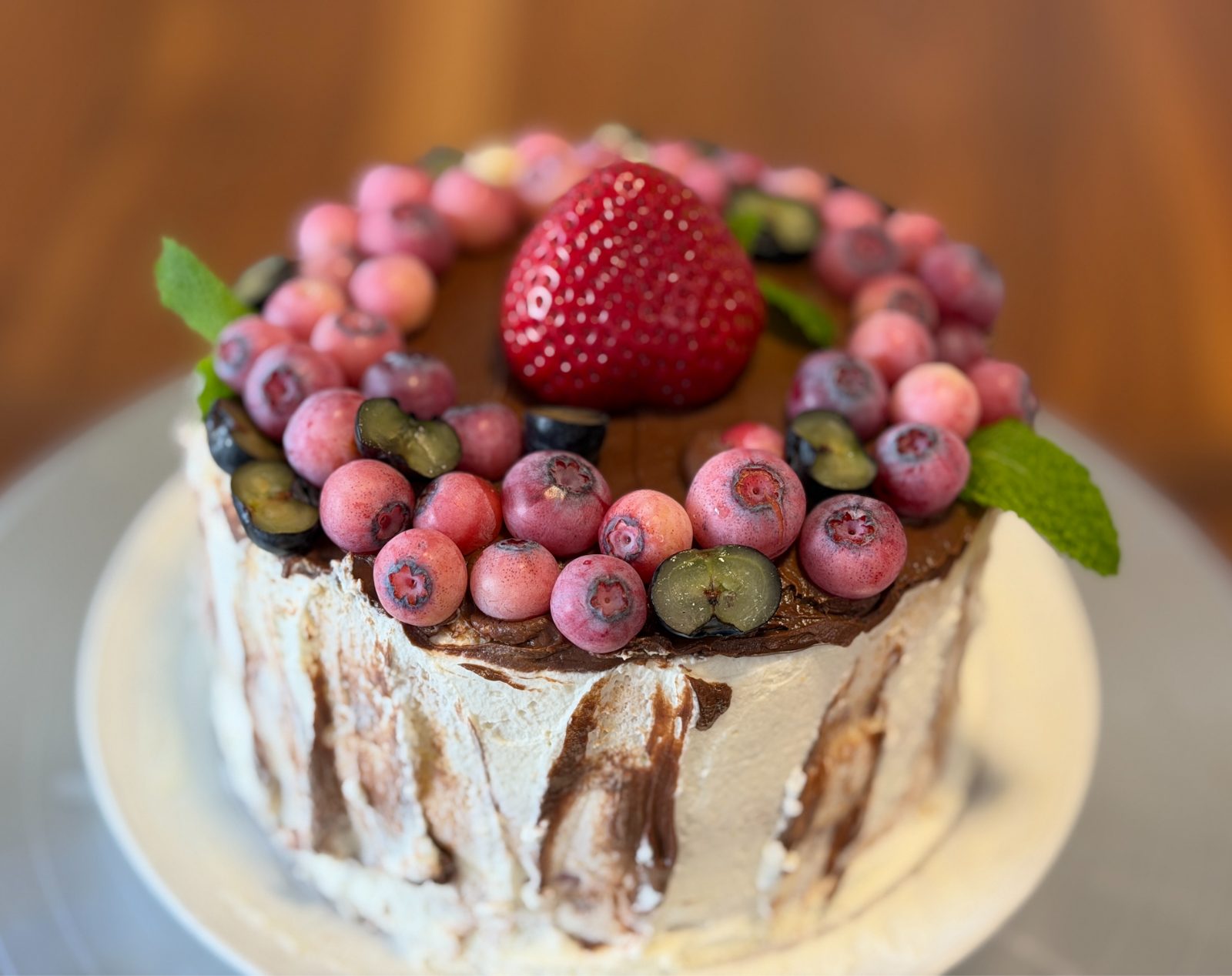 Organic cake topped with fresh berries and mint