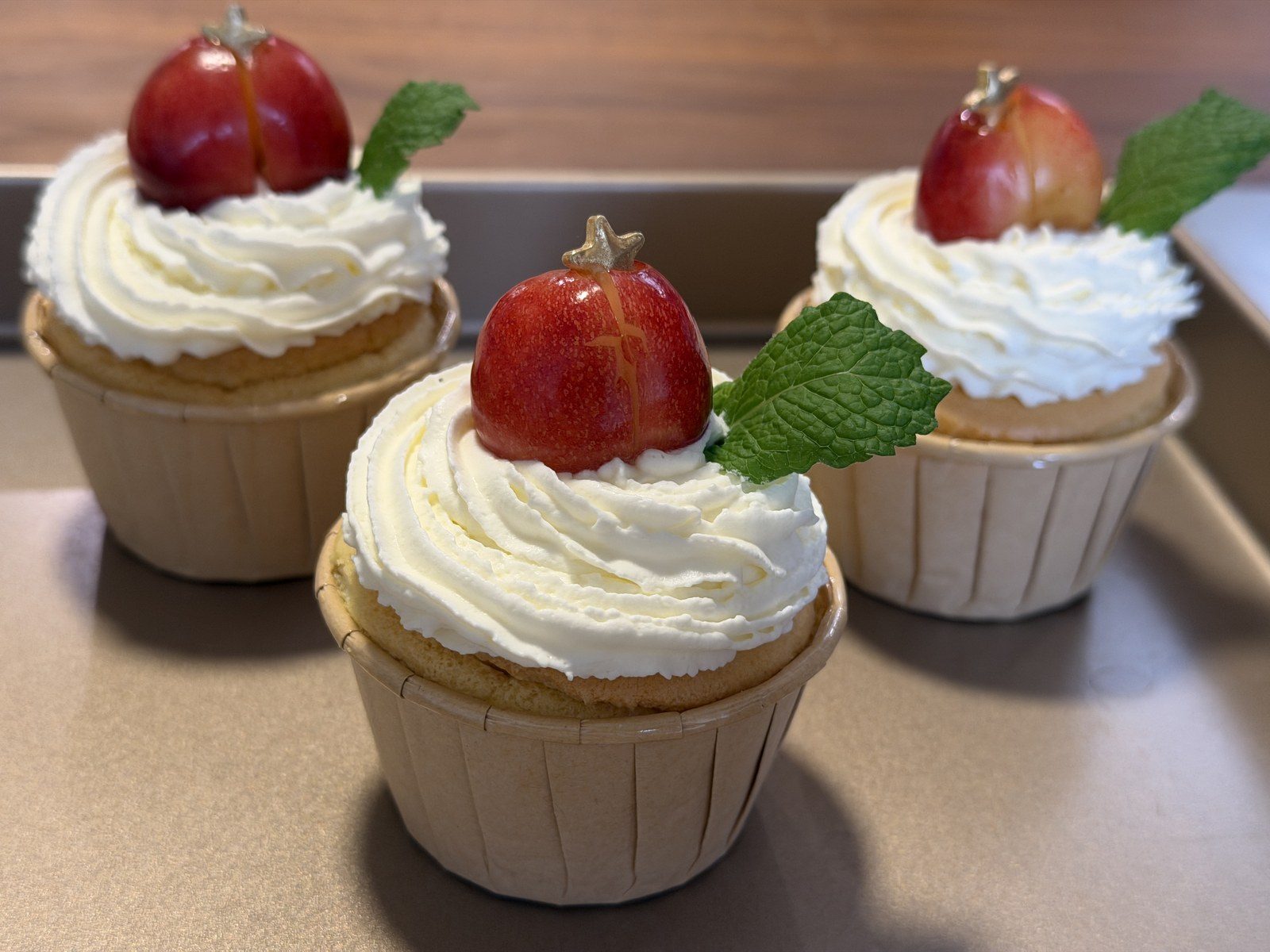 Cupcakes topped with plums and fresh mint