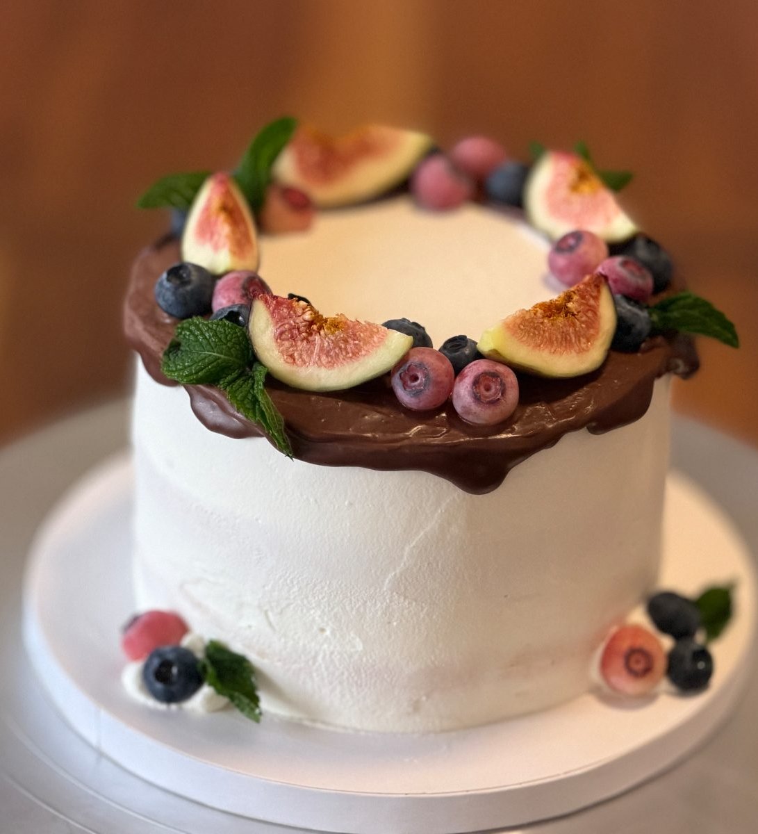 Fig and berry cake with a chocolate ganache rim, fresh figs, blueberries and mint
