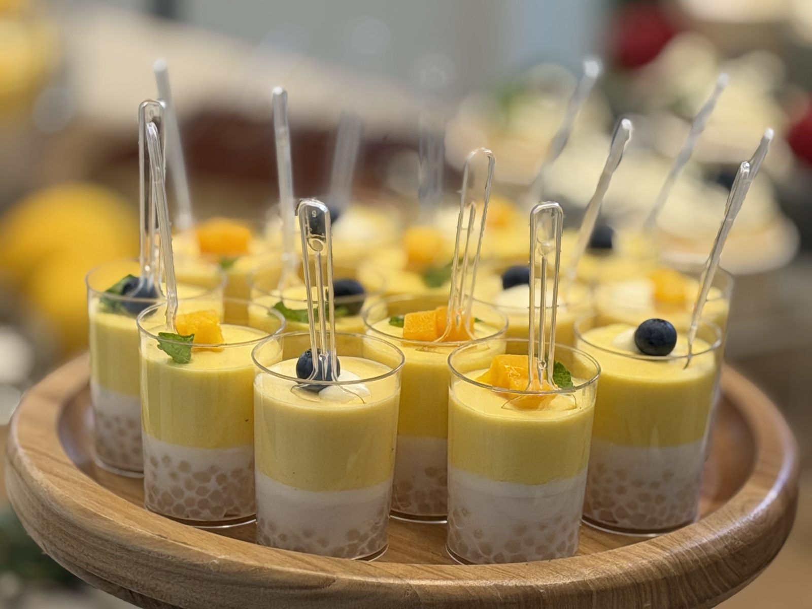 Mango coconut mousse cups layered over a tapioca base, topped with mango, blueberry and mint